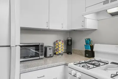 a white kitchen with a stove and a microwave at 500 ft to Ocean Relaxing stay Parking WiFi 834 in San Diego