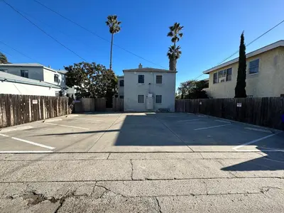 a parking lot with a house and a fence at 500 ft to Ocean Relaxing stay Parking WiFi 834 in San Diego