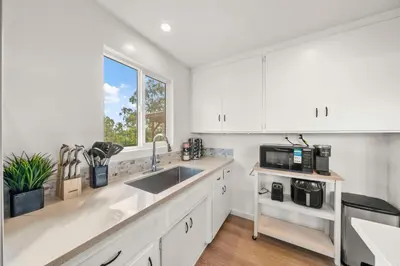 a white kitchen with a sink and a microwave at Parkside Paradise in San Diego