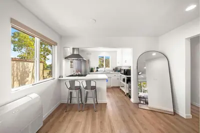 a white kitchen with two bar stools and a counter at Parkside Paradise in San Diego