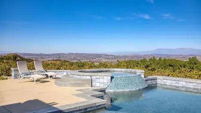 a swimming pool with two chairs and a patio at Summit Ranch by AvantStay Infinity Pool Views in Temecula