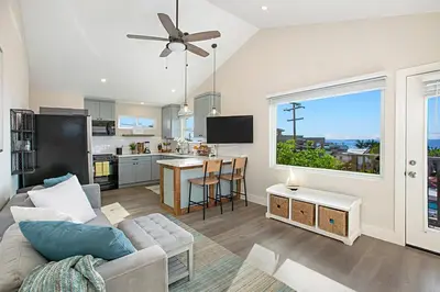 a living room with a couch and a kitchen at New with Panoramic View in Sunset Cliffs in San Diego