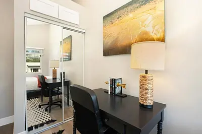 a room with a desk with a lamp and a bedroom at New with Panoramic View in Sunset Cliffs in San Diego
