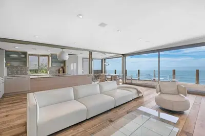 a living room with a white couch and a view of the ocean at Hi-Tech Hideaway - Modern & Ocean Front! in Solana Beach