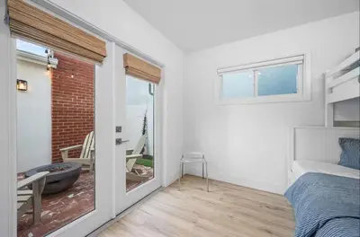 a bedroom with a bed and a balcony with a tub at Balboa Beach Getaway Steps2Sand Firepit BBQ in Newport Beach