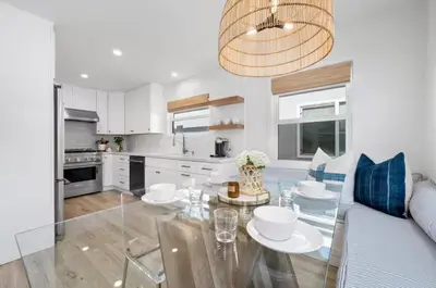 a kitchen and dining room with a glass table at Balboa Beach Getaway Steps2Sand Firepit BBQ in Newport Beach