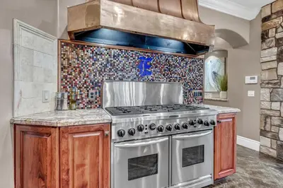 a kitchen with a stove and a tile wall at Secluded Boulder Groves Resort Getaway! in Ramona