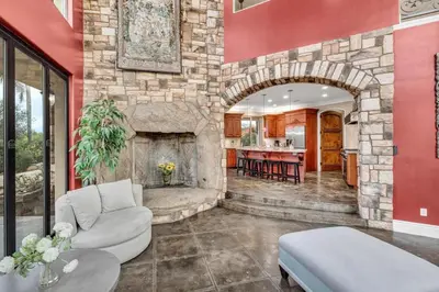 a living room with a stone fireplace in a house at Secluded Boulder Groves Resort Getaway! in Ramona