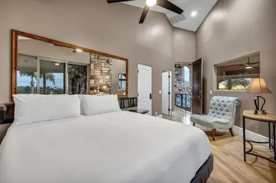 a bedroom with a large white bed and a chair at Secluded Boulder Groves Resort Getaway! in Ramona