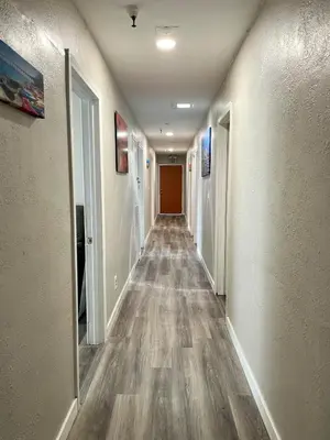 a hallway with a long corridor with white walls at North Park Centrally located 8Br 5Ba House in San Diego