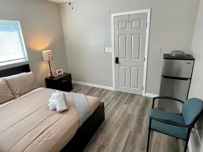 a bedroom with a bed and a blue chair at North Park Centrally located 8Br 5Ba House in San Diego