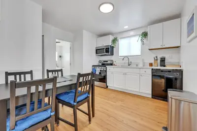a kitchen with white cabinets and a table and chairs at Harborside Suite 12 with Hot Tub and King Beds in San Diego