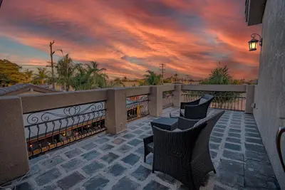 a balcony with two chairs and a sunset at San Diego Large Luxury home near Downtown in San Diego