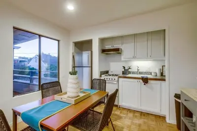 a kitchen with a table and chairs and a kitchen with a window at Beryl Bungalow in San Diego