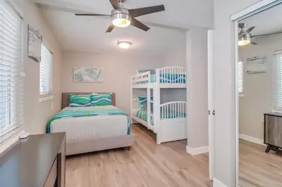 a bedroom with two bunk beds and a ceiling fan at Casa Azul Lower in San Diego