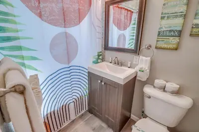 a bathroom with a sink and a toilet and a mirror at Casa Azul Lower in San Diego