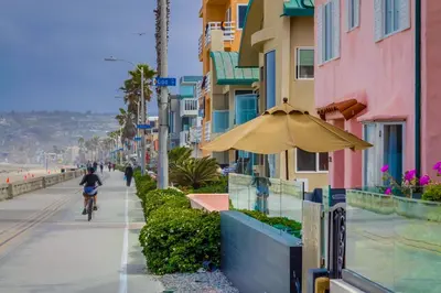a person riding a bike down a sidewalk with an umbrella at Casa Rosa in San Diego