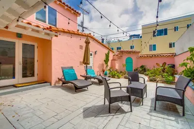 a patio with chairs and tables and a building at Casa Rosa in San Diego