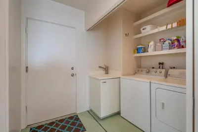a small kitchen with white cabinets and a sink at Casa Rosa in San Diego