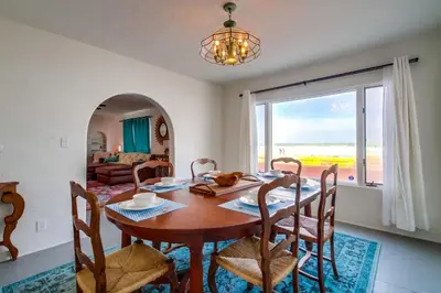 a dining room with a table and chairs and a couch at Casa Rosa in San Diego