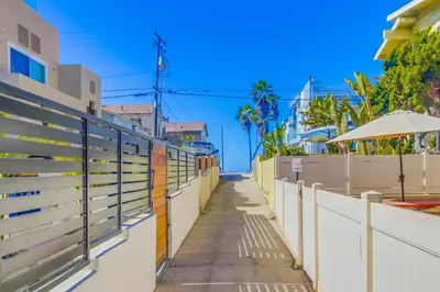 a walkway with a fence and an umbrella at Coastal Haven in San Diego