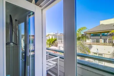 an open door to a balcony with a view of the beach at Coastal Haven in San Diego
