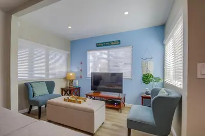 a room with a bed and two chairs and a tv at Cozy Kingston 1 in San Diego