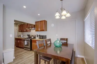 a kitchen with a wooden table and a dining room at Cozy Kingston 1 in San Diego