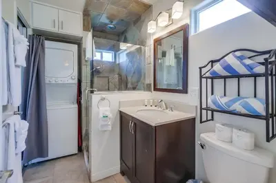 a bathroom with a sink and a toilet and a mirror at Manhattan Shores 1B in San Diego