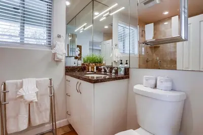 a bathroom with a toilet and a sink and a mirror at Ocean Breeze 1 in San Diego