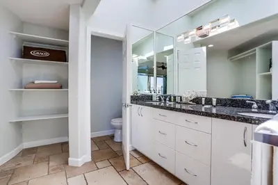 a bathroom with white cabinets and a sink and a toilet at Ocean Breeze 1 in San Diego