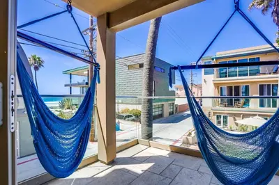 two hammocks on a balcony with a view of the ocean at Ocean Breeze 1 in San Diego