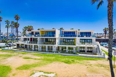 a large white building with palm trees and a parking lot at Ocean Park 03 in San Diego