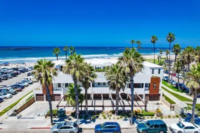 a white building with palm trees and the beach at Ocean Park 03 in San Diego
