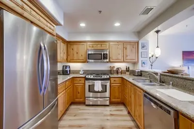 a kitchen with wooden cabinets and a stainless steel refrigerator at Pacific Paradise in San Diego
