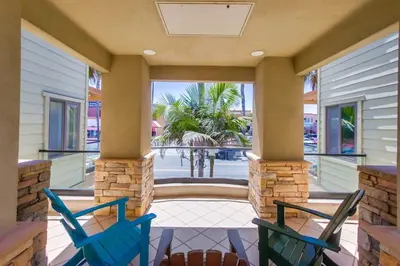two blue chairs on a porch with a view of a courtyard at Pacific Paradise in San Diego