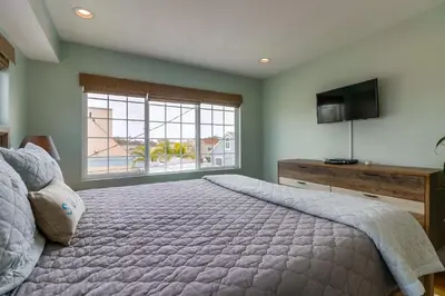 a bedroom with a large bed and a television at Seaglass Shores in San Diego