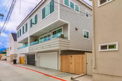 a large white building with a balcony on a street at Seaglass Shores in San Diego