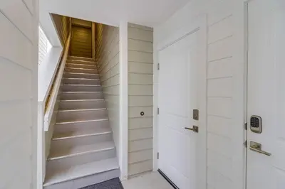 a staircase in a house with white walls and white floors at Seaglass Shores in San Diego