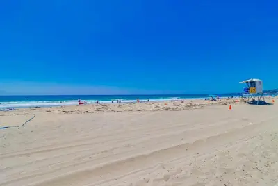 a sandy beach with a lifeguard tower and the ocean at Surf Rider D in San Diego