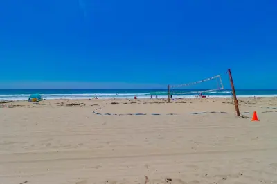 a volleyball net on a beach with the ocean at Surf Rider D in San Diego