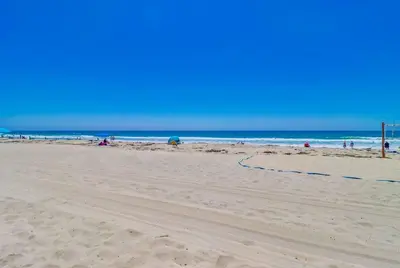 a beach with people on the sand and the ocean at Surf Rider D in San Diego