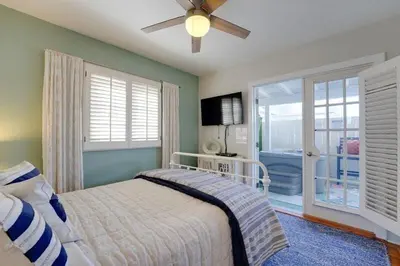 a bedroom with a bed and a ceiling fan at Coral Cottage in San Diego