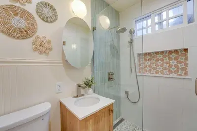 a bathroom with a sink and a glass shower at Coral Cottage in San Diego