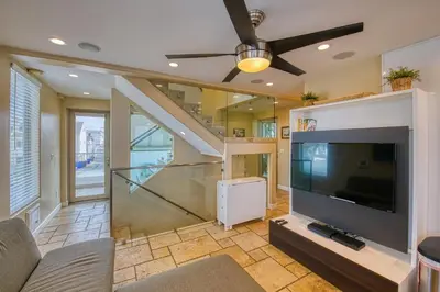a living room with a flat screen tv and a staircase at Ocean View Luxury 2 in San Diego