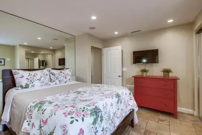 a bedroom with a bed with a red dresser and a tv at Ocean View Luxury 2 in San Diego
