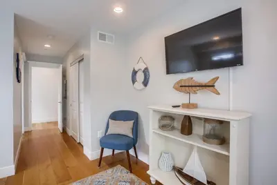 a room with a blue chair and a tv on a wall at Pacific Pearl in San Diego