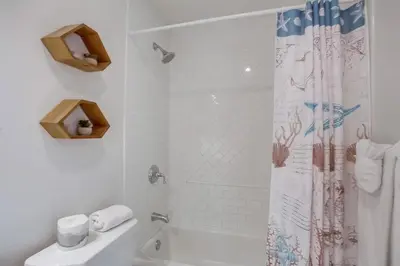 a bathroom with a shower with a toilet and a sink at Pacific Pearl in San Diego