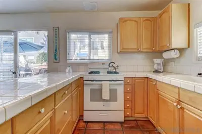a kitchen with wooden cabinets and a stove top oven at South Mission Oceanview Beach Duplex in San Diego