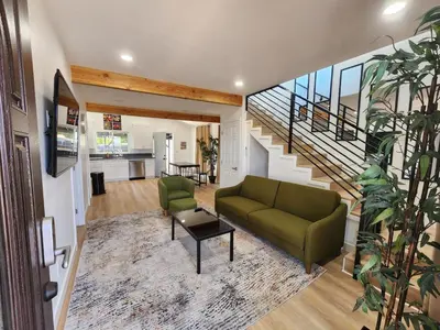 a living room with a green couch and a staircase at Best Location pet friendly Home just renovated in Chula Vista